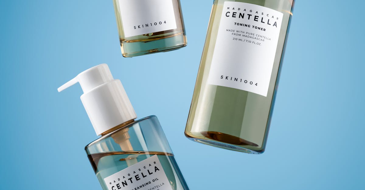 Skincare products including serum, toner, and cleansing gel on a blue background.